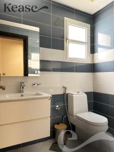een badkamer met een toilet, een wastafel en een spiegel bij Kease Qurtubah A-9 Royal Design AG97 in Riyad