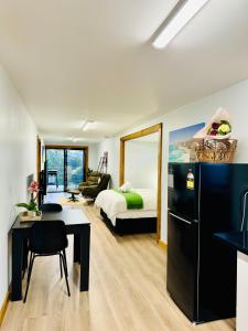 a room with a kitchen and a bedroom with a bed at GORGE Chocolates Tiny House in Kennedys Creek