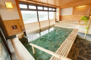 a pool of water in a room with benches at Takayama Ouan in Takayama
