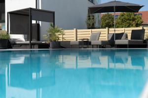basen z leżakami i parasolem w obiekcie Kracher Hotel Doppelzimmer - für maximal 4 Personen inklusive Pool w mieście Illmitz