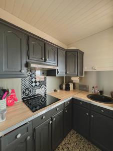 a kitchen with black cabinets and a counter top at superbe t2 200 m de la plage 4SUF502 in Le Barcarès +10 photos