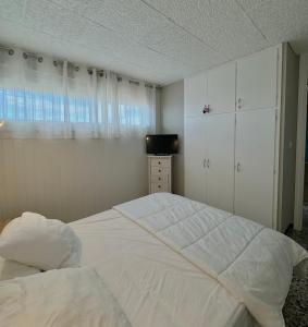 a bedroom with a large white bed and a window at superbe t2 200 m de la plage 4SUF502 in Le Barcarès