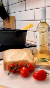 a piece of bread and tomatoes on a plate with a bottle of wine at Casa a Bosa in centro storico in Bosa