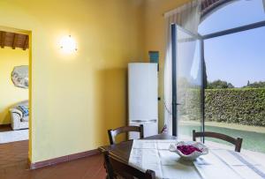 a dining room with a table and a large window at Country House Oasi Verde Near Florence in Cerreto Guidi