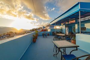 a balcony with tables and chairs on a building at Casa Voyager 'secret garden terrace' in Chefchaouen