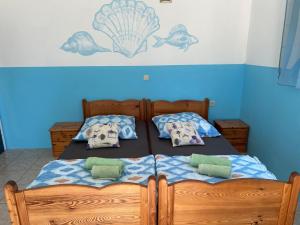 a bedroom with two beds with pillows and a painting on the wall at Apartments Lilly Weiss in Banjol