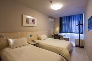 a hotel room with two beds and a window at Jinjiang Inn Datong Pingcheng Bridge in Datong +21 photos