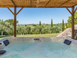 a hot tub in a backyard with an umbrella at Country House Oasi Verde Near Florence in Cerreto Guidi