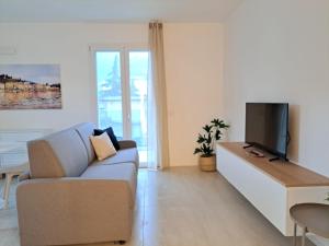 a living room with a couch and a tv at Lario Suite Apartments by Quokka 360 - Close to Como Downtown in Como