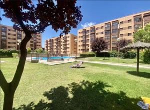 a park with a chair in the grass in front of a building at campezo in Madrid