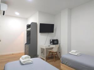 A television and/or entertainment centre at Casa de Huéspedes 12 Octubre Rooms Még 35 kép