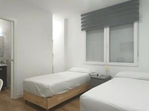 Łóżko lub łóżka w pokoju w obiekcie Casa de Huéspedes 12 Octubre Rooms