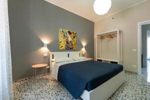 a bedroom with a large bed with a blue blanket at L'affaccio sulla Piazza in Avezzano