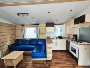 a living room with a blue couch in a kitchen at Camping Roc de l'Arche in Espalion