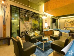 sala de estar con 2 sillas y mesa en Sea Front Home Hotel - Patong Beach, en Patong Beach