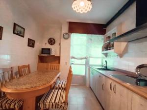 a kitchen with a counter and a sink and a table at Sobre el Puerto in Viveiro