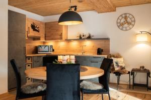 a kitchen and dining room with a wooden table and chairs at Appartement Bergwild in Bürserberg