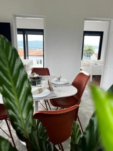 a dining room with a table with chairs and a plant at Meldaria Residence in Krk