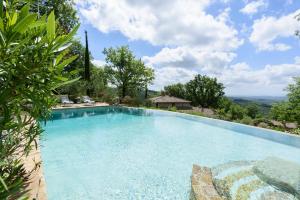 a large swimming pool with a view of the mountains at Villa Tregole by Mmega in Fonterutoli