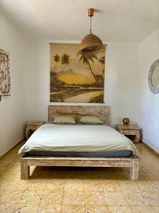 a bedroom with a bed with a painting on the wall at Studio Aqua in La Oliva