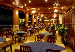 a dining room with tables and chairs and lights at Samui First House Hotel in Chaweng