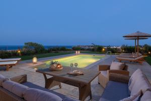 a patio with a table and chairs and a pool at Majestic View Villa in Kolymbia