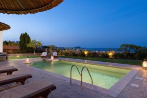 a swimming pool at night with a view of the city at Majestic View Villa in Kolymbia +31 photos