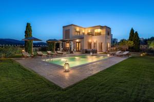a villa with a swimming pool at night at Majestic View Villa in Kolymbia
