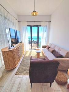 a living room with a couch and a flat screen tv at Cabacum Paradise 1 on the seashore in Varna City