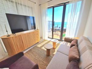 a living room with a couch and a flat screen tv at Cabacum Paradise 1 on the seashore in Varna City