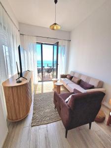 a living room with a couch and a table and a television at Cabacum Paradise 1 on the seashore in Varna City