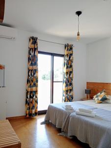 a bedroom with a bed and a large window at Quinta da Norinha in Portimão