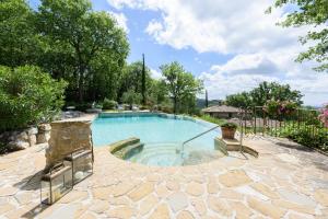 a swimming pool in a yard with a stone patio at Villa Tregole by Mmega in Fonterutoli +37 photos