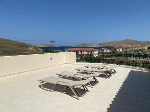 a row of lounge chairs sitting on a patio at Ammos Suites in Platy