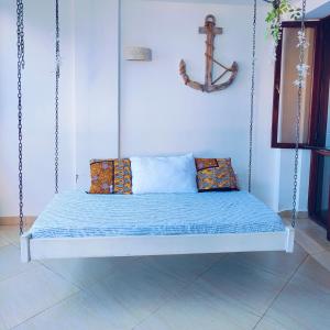 a swing bed with pillows and a cross on the wall at Beach Front Luxury 2 Bedroom Mombasa in Mombasa
