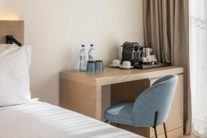 a hotel room with a desk and a chair at Crowne Plaza - Caparica Lisbon in Costa da Caparica