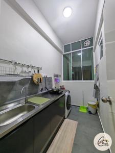 une cuisine avec un évier et une machine à laver dans l'établissement Trival Blessing Cottage Homestay Sri Indah Sandakan, à Sandakan