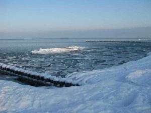 a large body of ice in the water with snow at Kastanienallee zwischen Zentrum und Seebrücke in Graal-Müritz