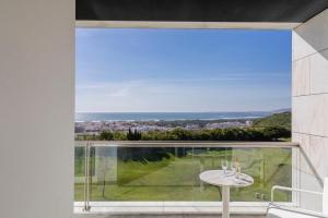 a view from the balcony of a house with a table at Crowne Plaza - Caparica Lisbon in Costa da Caparica