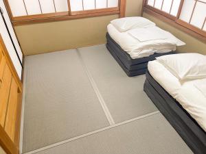 富士吉田市OPENSALE Hoco 富士吉田富士山ビューの上質な宿 駅近 本町撮影スポット徒歩1分的带窗户的客房内的两张单人床
