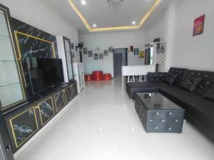 a living room with a black couch and a tv at ratchanun my home in Ban Khlong Toei (1)