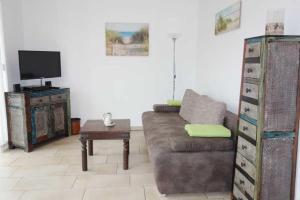 a living room with a couch and a tv at Küstenwald - Ferienwohnung Igel 67 in Müritz