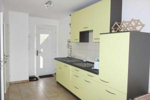 a kitchen with yellow cabinets and a white refrigerator at Küstenwald - Ferienwohnung Igel 67 in Müritz