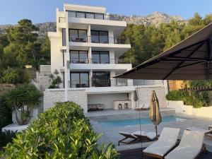 a building with a swimming pool and a resort at Soho Apartments Brela in Brela