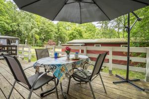 a table and chairs with an umbrella on a deck at Bungalow Seeschwalbe, Nr 7 in Dranske
