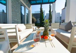 a table with two glasses of wine and a bowl of fruit at Seafront Villa Layla by Ruidoso Luxury in Ayia Napa