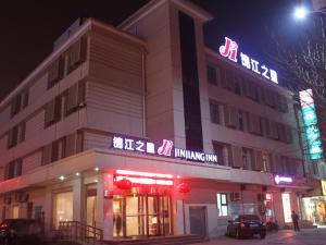 a building with a sign on the side of it at night at Jinjiang Inn Dezhou Railway Station in Dezhou