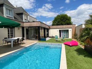 a swimming pool in the yard of a house at Lady Jule Chambres d hôtes & spa in Sainte-Luce-sur-Loire