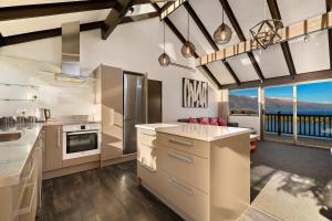 a kitchen with white cabinets and a view of the mountains at Lake Views - Close to Town - Hot Tub - Spa Pool in Queenstown