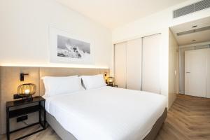 a bedroom with a large white bed in a room at Crowne Plaza - Caparica Lisbon in Costa da Caparica